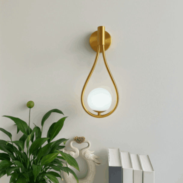 Bathroom globe light fixture with teardrop glass and solid brass base, delivering elegant illumination in modern vanity or sink areas.