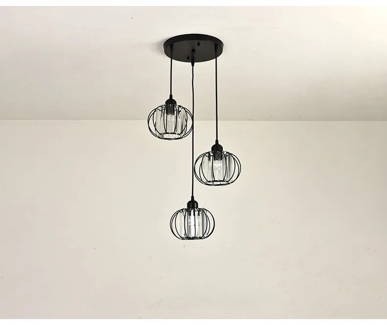 A trio of black and white pendant lights hang from the ceiling, adding a chic vibe to the space.