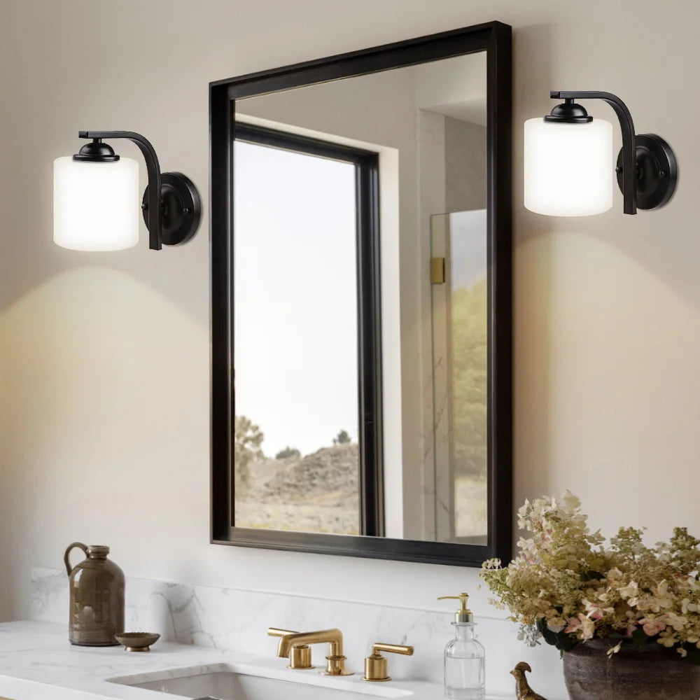 A bathroom featuring a sink and two overhead lights illuminating the space.