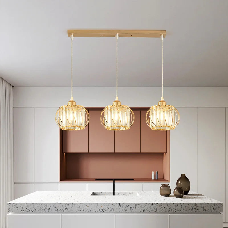 Three beautiful hanging lights illuminate a kitchen, creating a cozy and inviting atmosphere for cooking and dining.
