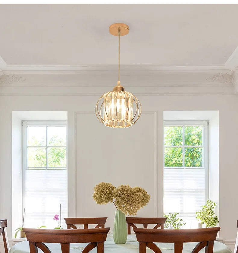A dining room table surrounded by chairs, illuminated by a stylish pendant light overhead.