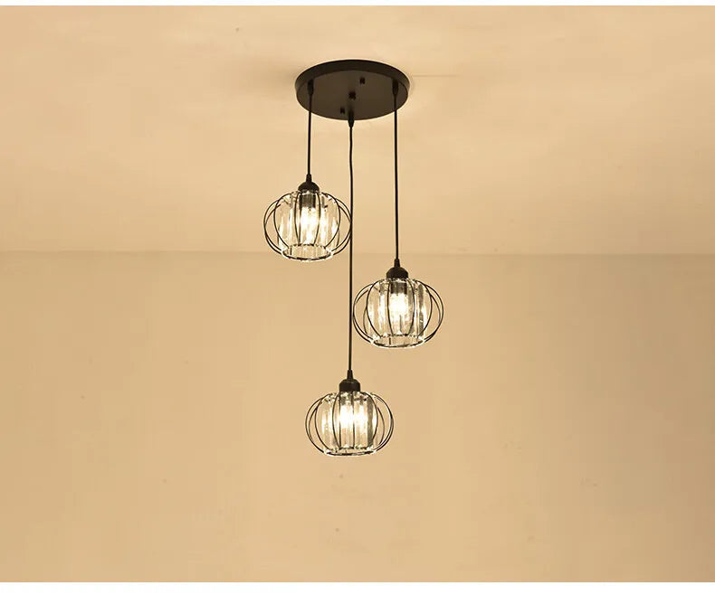A stylish chandelier with three lights and decorative glass balls hanging from it.