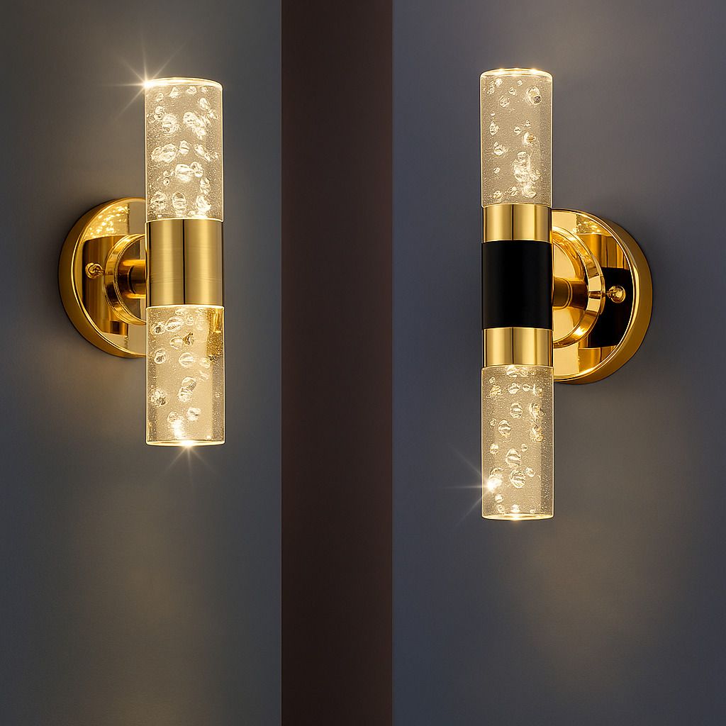 Dual gold bathroom wall sconce light with bubble acrylic cylinder design mounted on a dark wall.