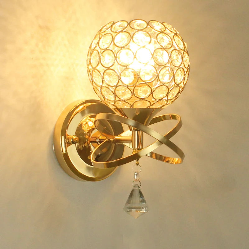 A stylish gold wall light with a shimmering crystal ball, perfect for enhancing any interior space.
