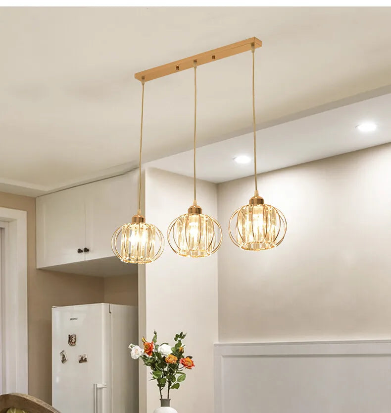 A trio of pendant lights illuminates a kitchen, creating a warm and inviting atmosphere.