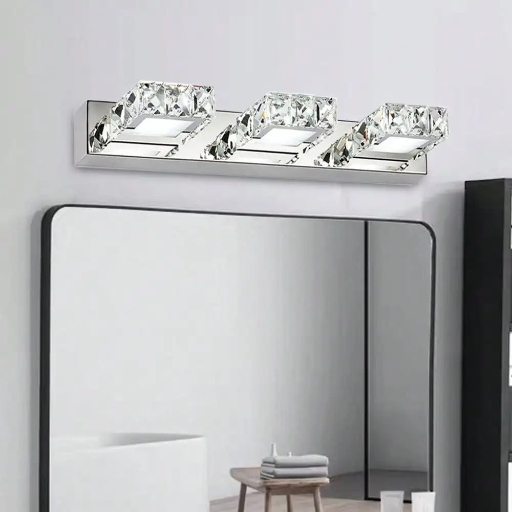 Modern crystal LED bathroom vanity light featuring three angled square crystal heads on a sleek chrome base, perfect for elegant illumination above mirrors.