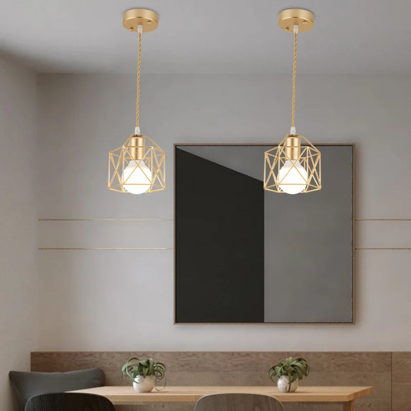 Modern pendant lights hang above a dining table, featuring a stylish Crystal Basket wall sconce on the wall.