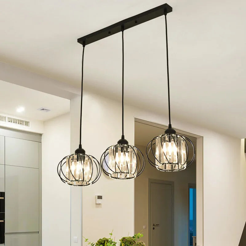 Three elegant light fixtures hang from the ceiling in a bright kitchen, adding style and warmth to the space.