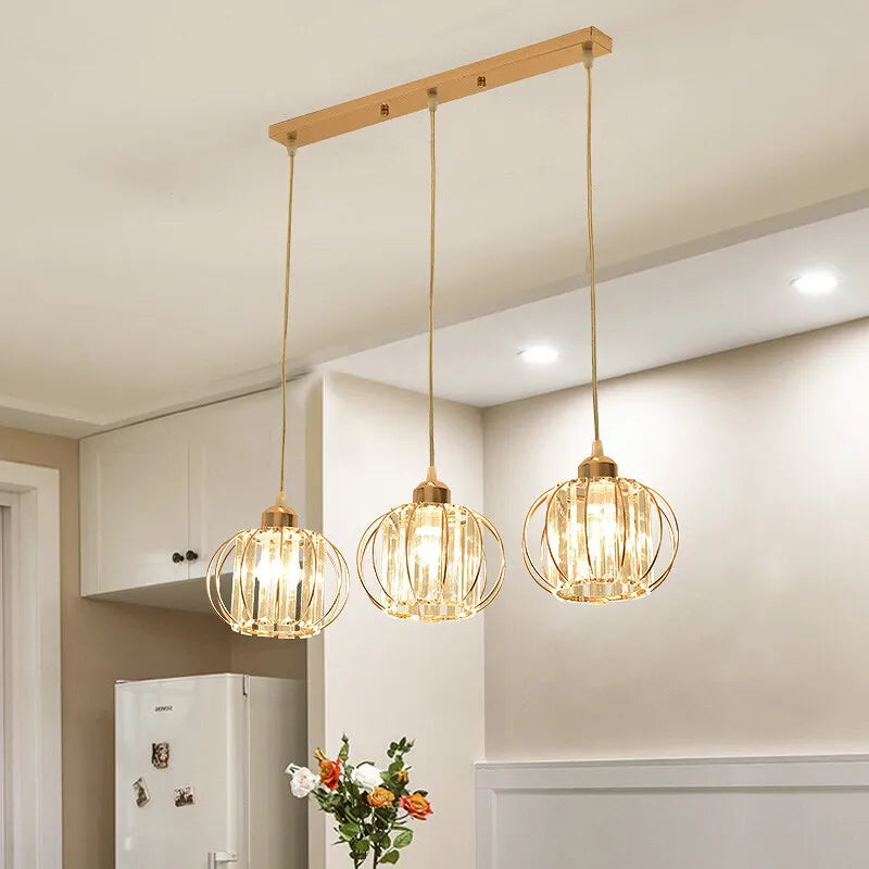 A trio of pendant lights illuminates a kitchen, creating a warm and inviting atmosphere for cooking and dining.