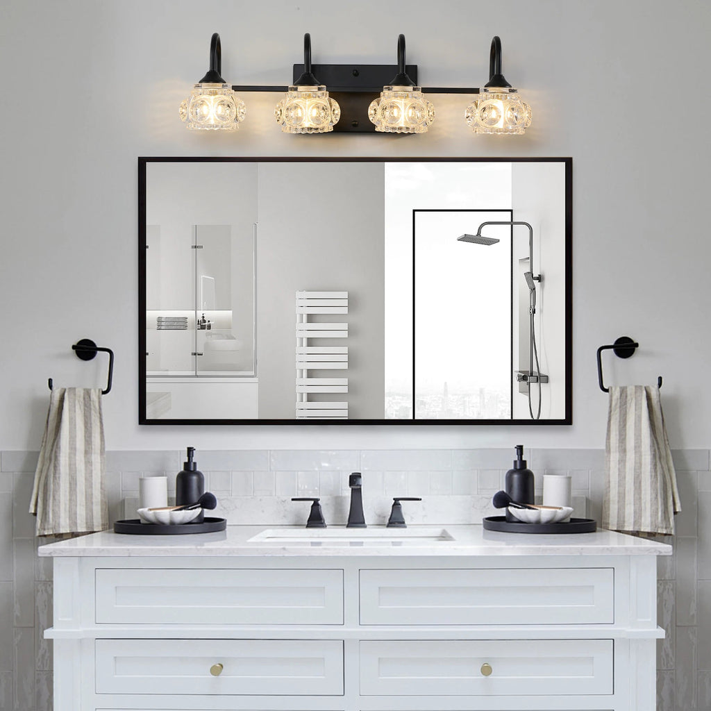 Three-light black vanity fixture with ornate glass shades, mounted above a bathroom mirror for classic elegance and bright illumination







